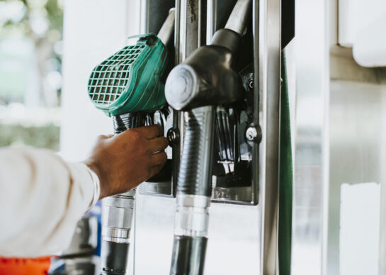 Man grabbing a fuel nozzle to refuel his vehicle