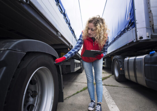 Truck driver checking vehicle tires and inspecting truck before ride.